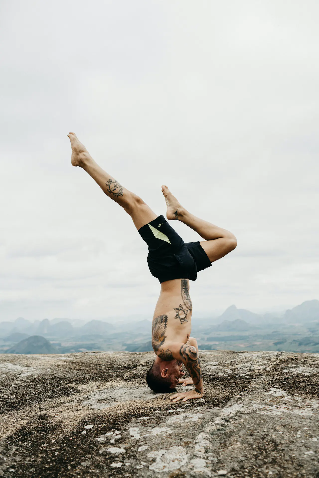 Man doing a handstand on a mountain