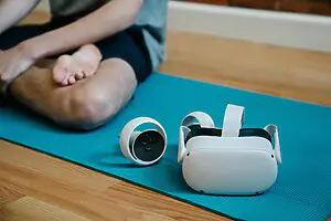 man sitting on a fitness mat with smart technology around time