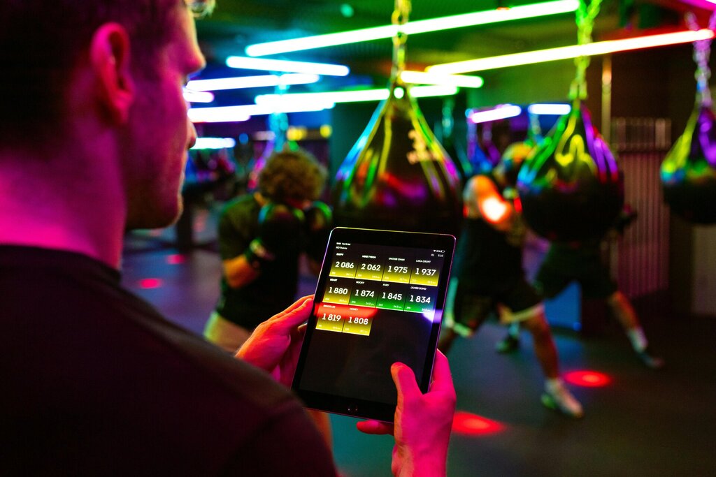 close up shot in a gym of a man holding an iPad monitoring his fitness stats